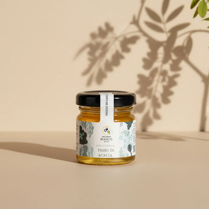 Small jar of honey with a label on artistic background